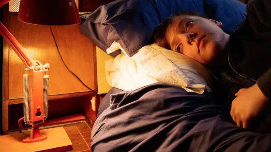 Teenage boy lying on a bed