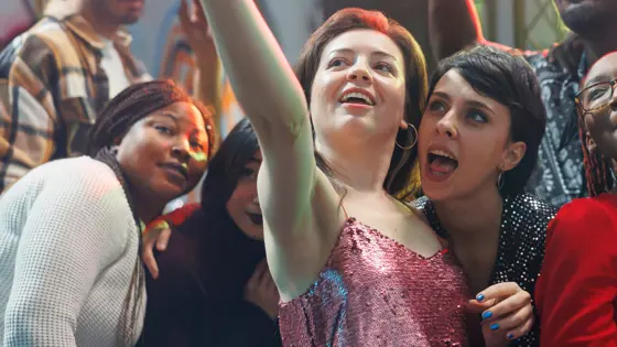 A photo group of young adults standing together and posing for a selfie.