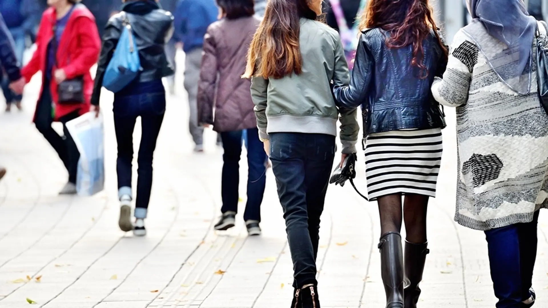 Three teenage girls walking down a street