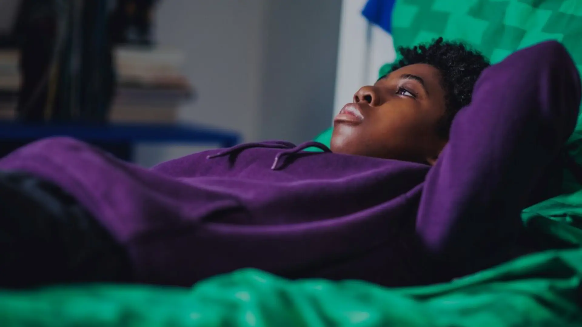 Photograph of a young child lying on their bed.