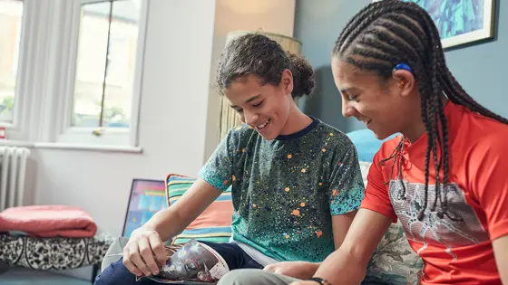 Photo of two friends reading a comic together.