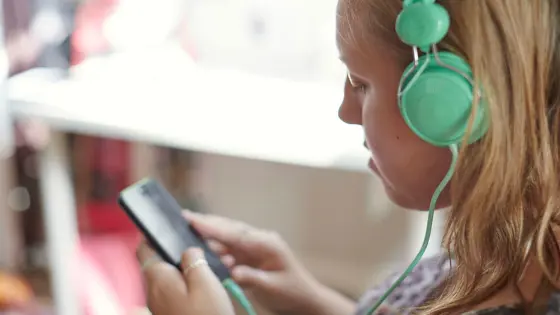 Girl using a phone with headphones on