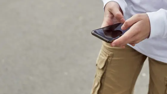 Young person using a mobile phone while outside
