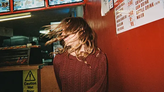A young person with their hair in their face