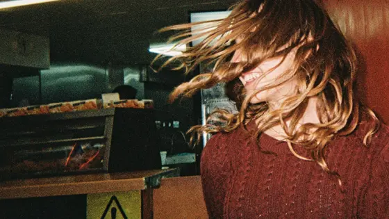 A young person with their hair in their face