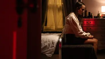 Teenage girl sat on a bed