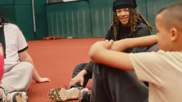 A group of teenagers sat down inside a basketball court