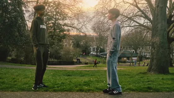 Photograph of two young people facing each other while outdoors.