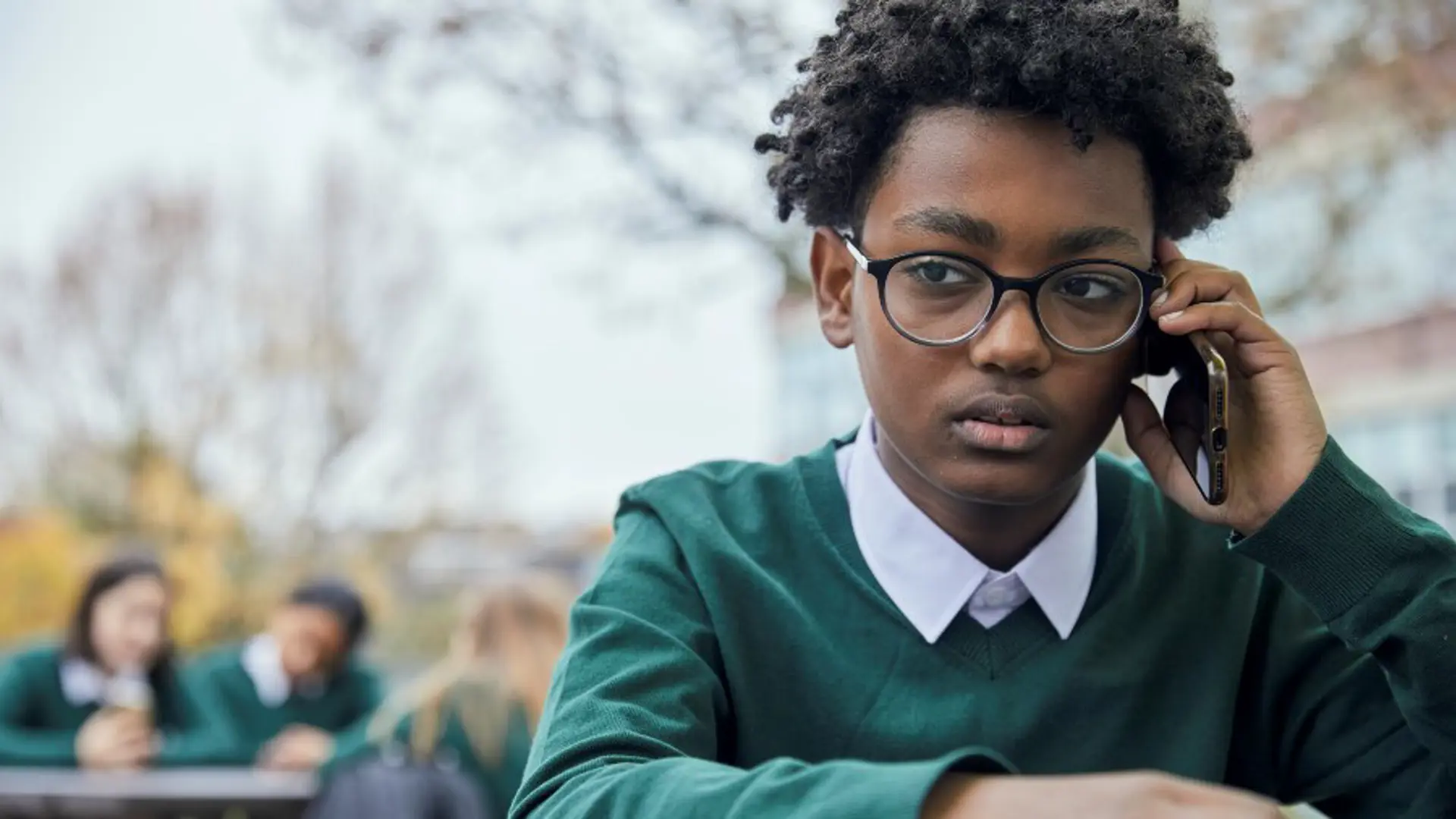 Photograph of a young boy on their phone.