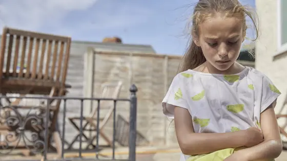 Young girl outside alone looking worried