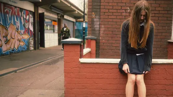 A teenager staring blankly at the ground.