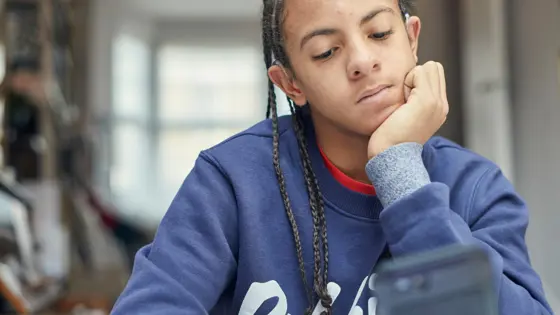 Boy looking down at his phone.