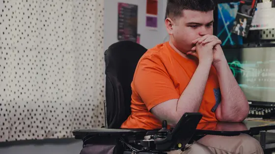 A young person sat in their bedroom