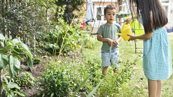 A  young boy and girl playing in a garden
