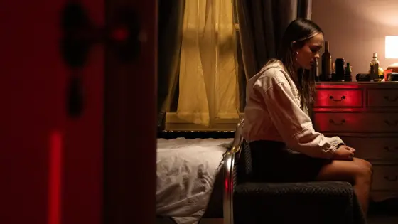 Teenage girl sat on a bed