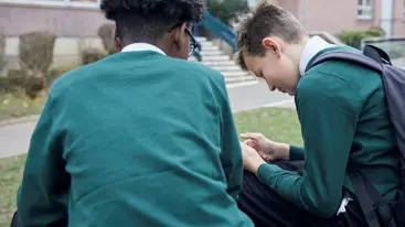 Two teenage boys sat outside.