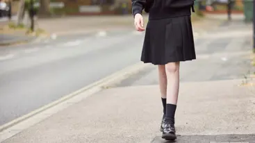 Photo of a child's legs as they walk down the street.