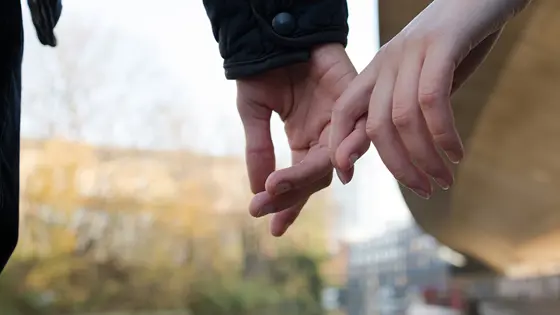 Two young people holding hands