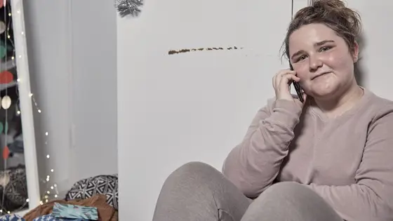 Teenage girl sat on the floor on their phone