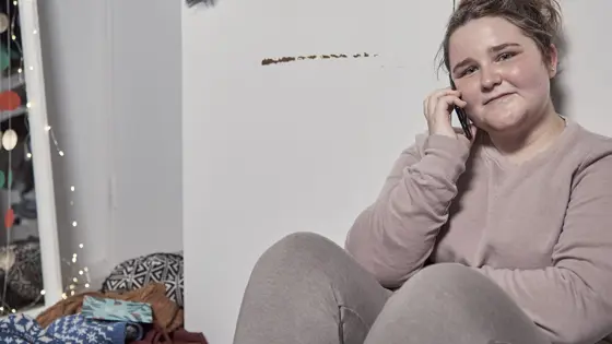 Teenage girl sat on the floor on their phone