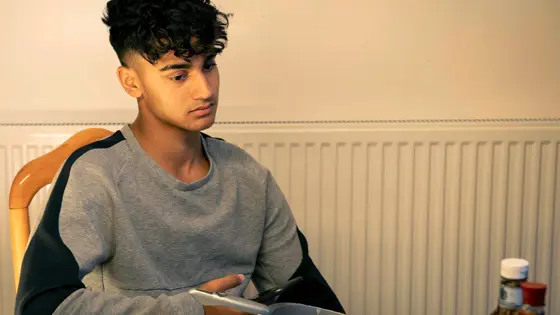 Young person sat at a table at home