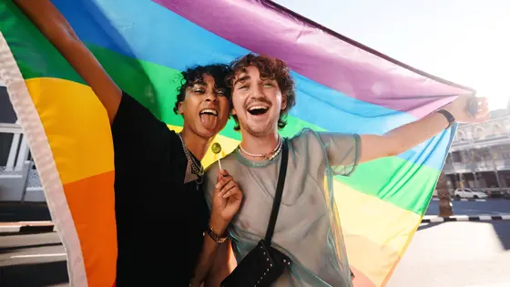 Two teenagers holding a Pride flag