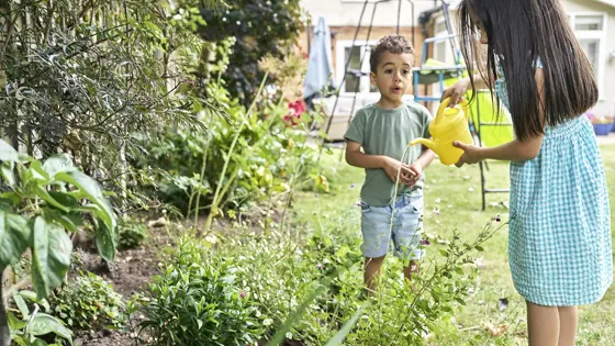 A  young boy and girl playing in a garden