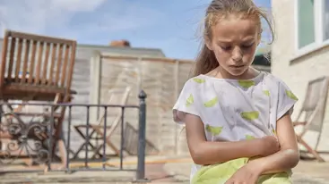 A young person looking down and looking sad