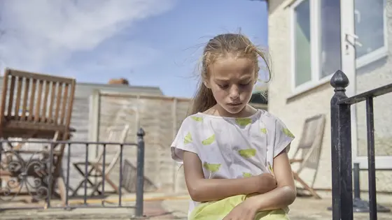 Young girl outside alone looking worried
