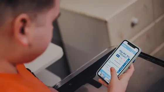 A young person looking at their mobile phone