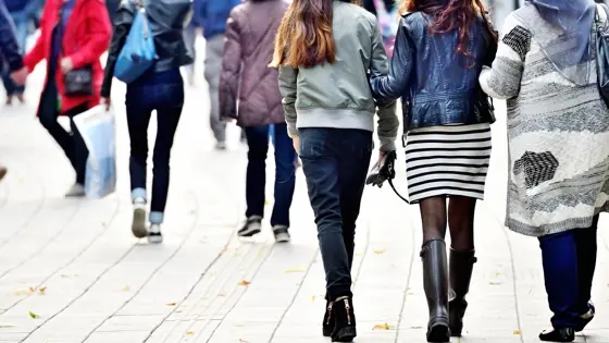 Three teenage girls walking down a street