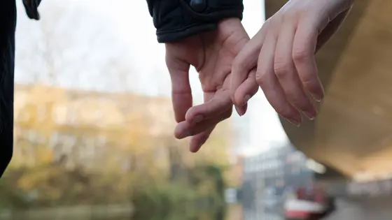 Two young people holding hands