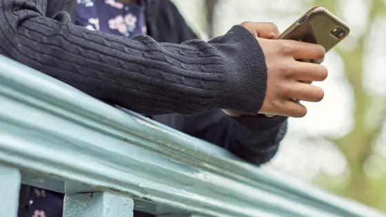 Photograph of a child using their mobile phone.