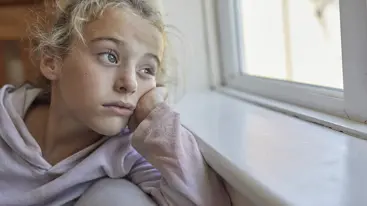 A young person looking out of a window