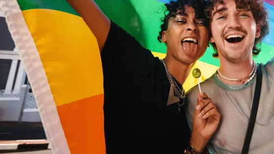 Two teenagers holding a Pride flag