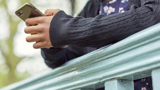 Photograph of a child using their mobile phone.