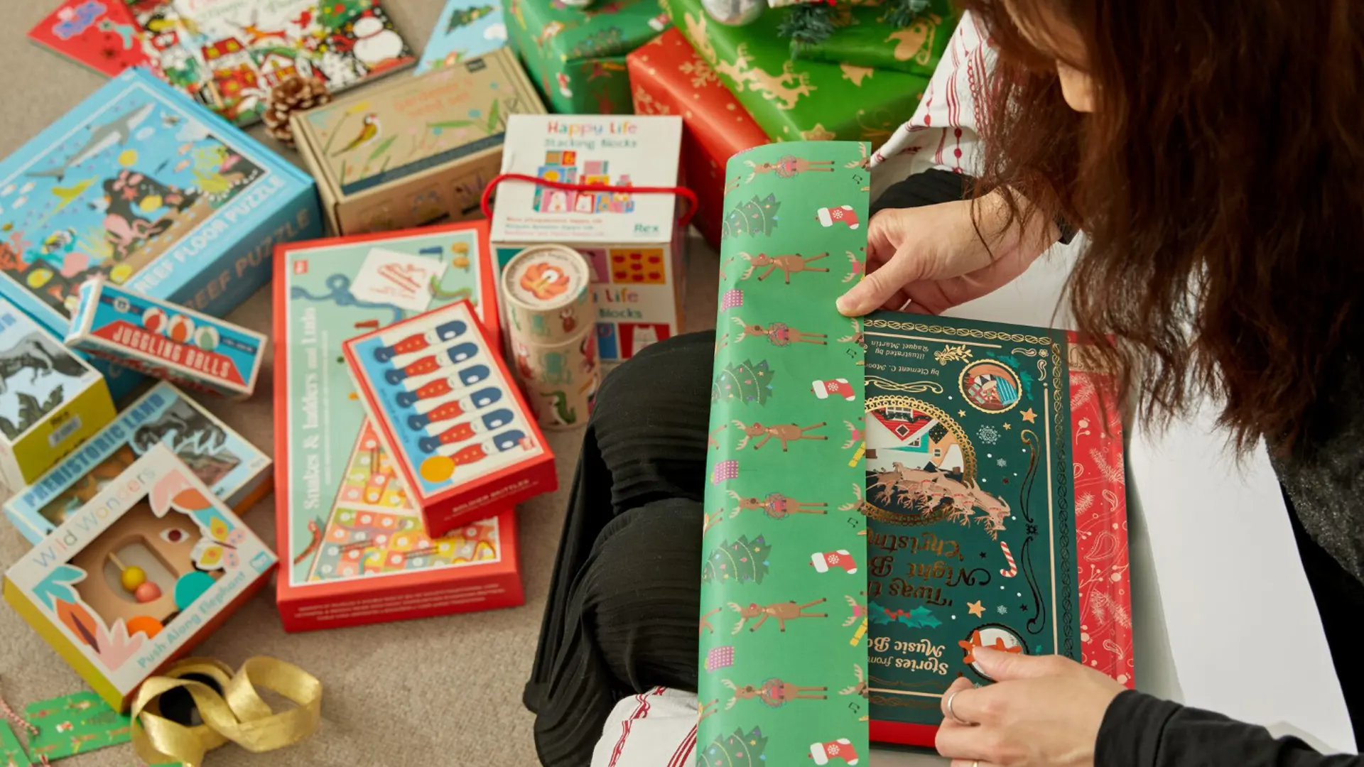Photograph of a woman wrapping Christmas gifts.