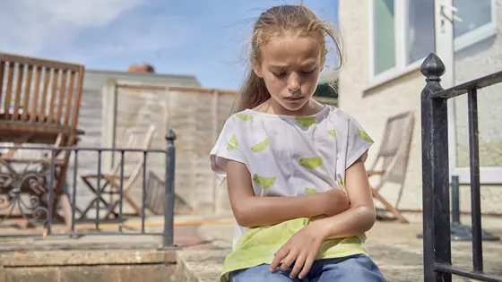 A young person looking down and looking sad