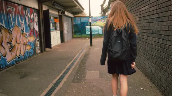 Photograph of a girl walking down a street.
